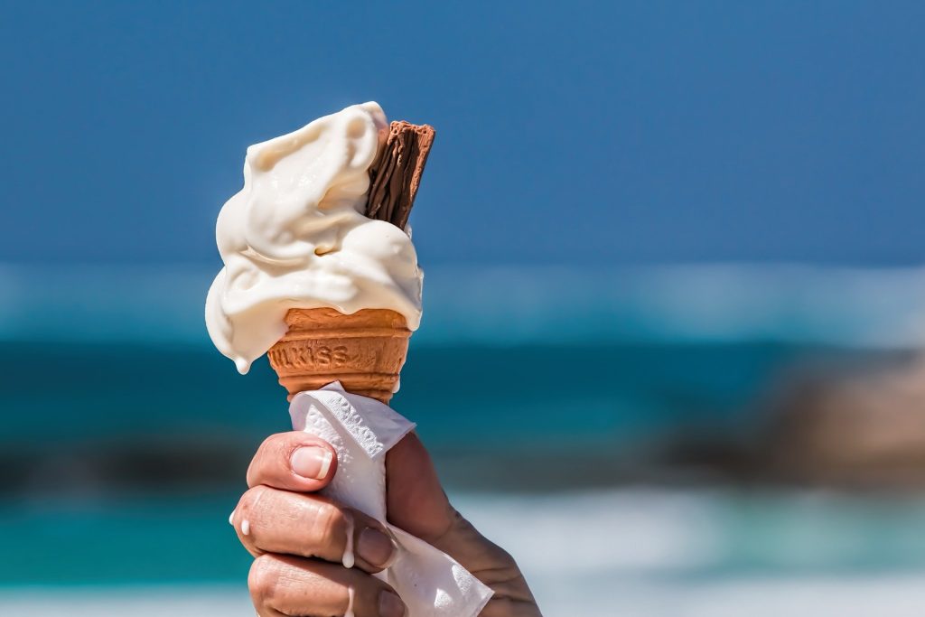 Ice cream cone in hand in toasting position