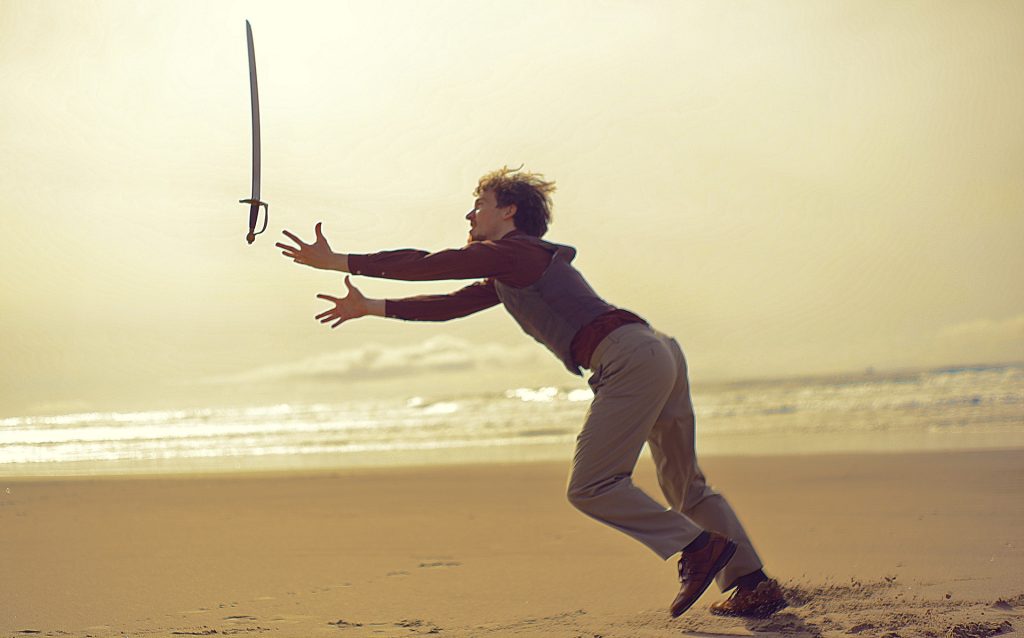 man is playing with the sword and looses a control of the weapon.