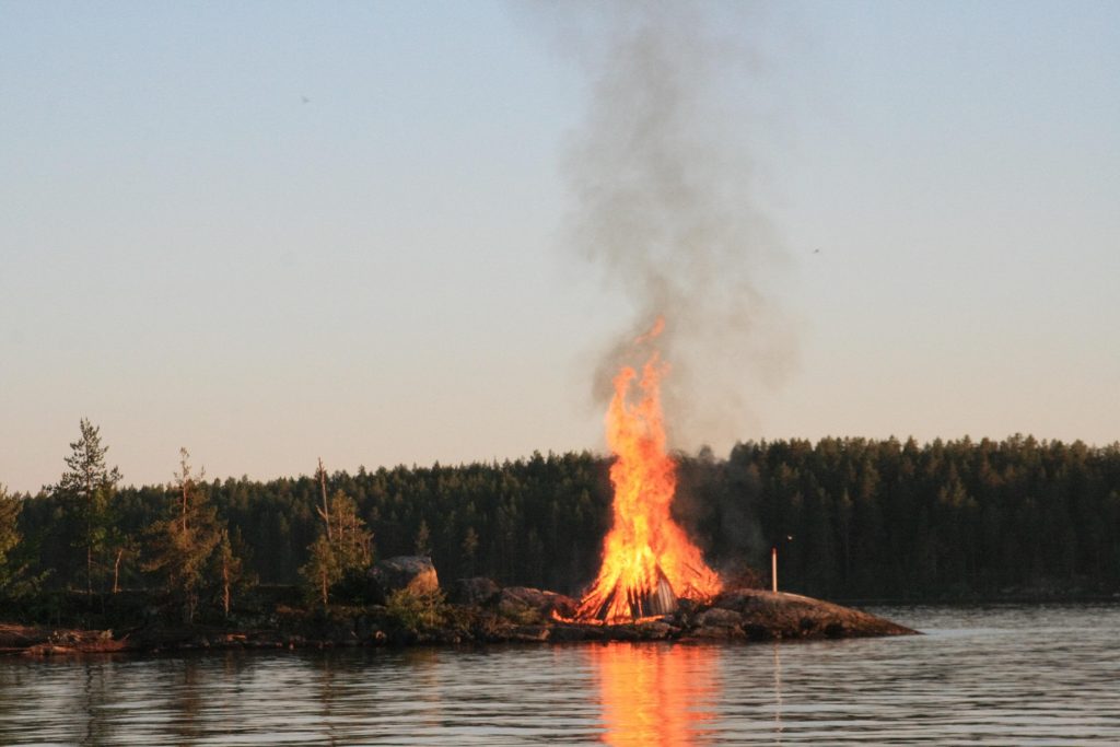Juhannuskokko palaa luodolla järven keskellä.